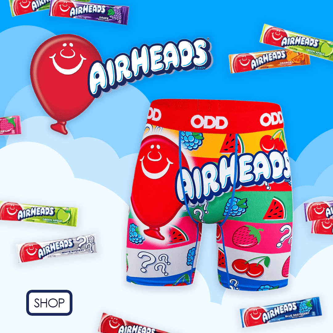 Colorful Airheads-themed boxer briefs with a red balloon logo and candy wrappers, set against a blue sky with clouds. Includes a 'Shop' button.